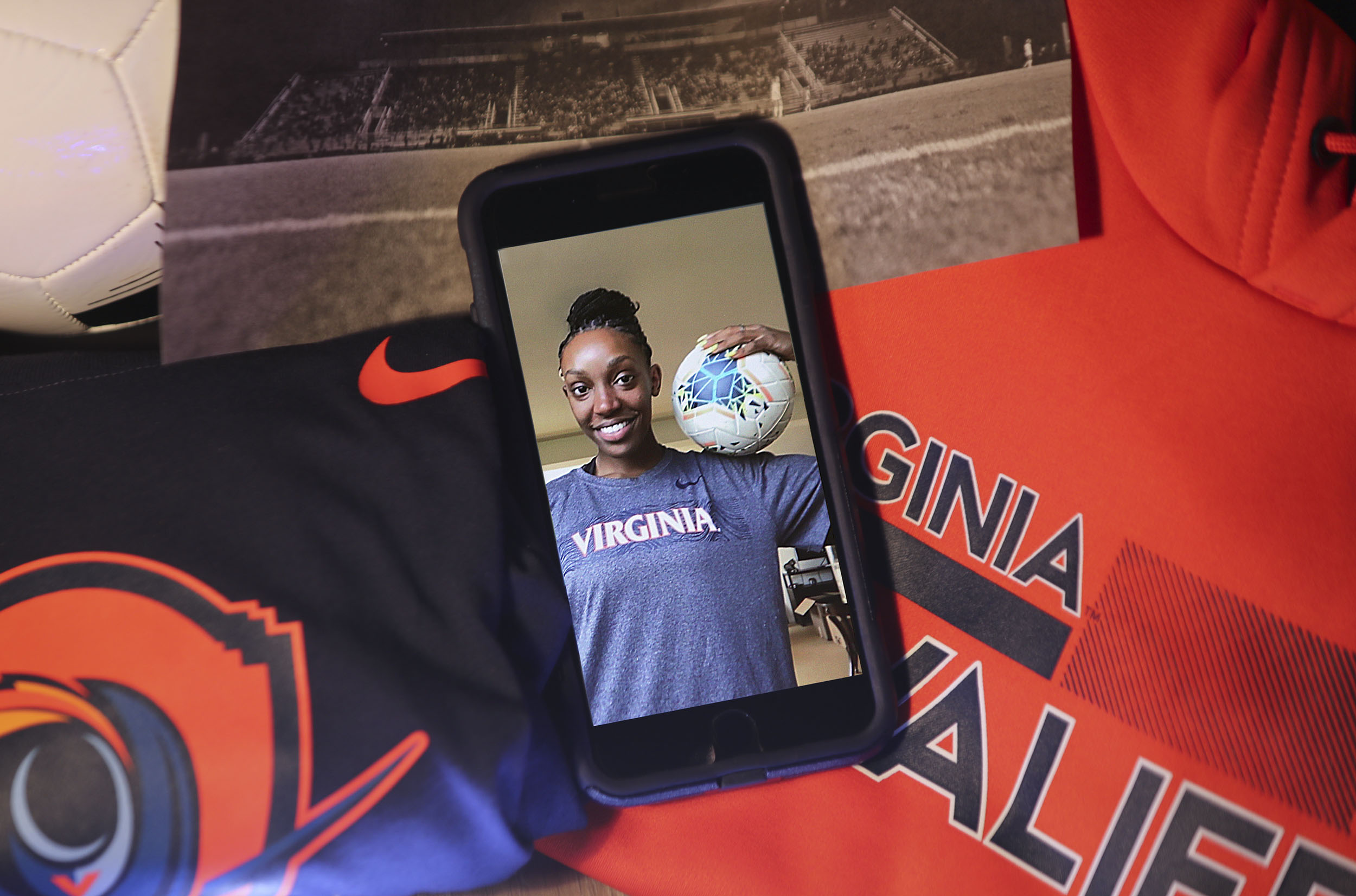 phone with a picture of a UVA womens volleyball player holding a volleyball 