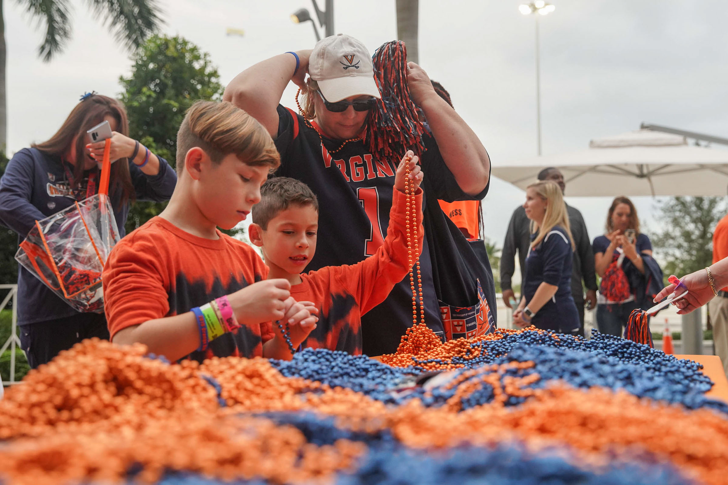 UVA fans at a table picking up blue and orange beads