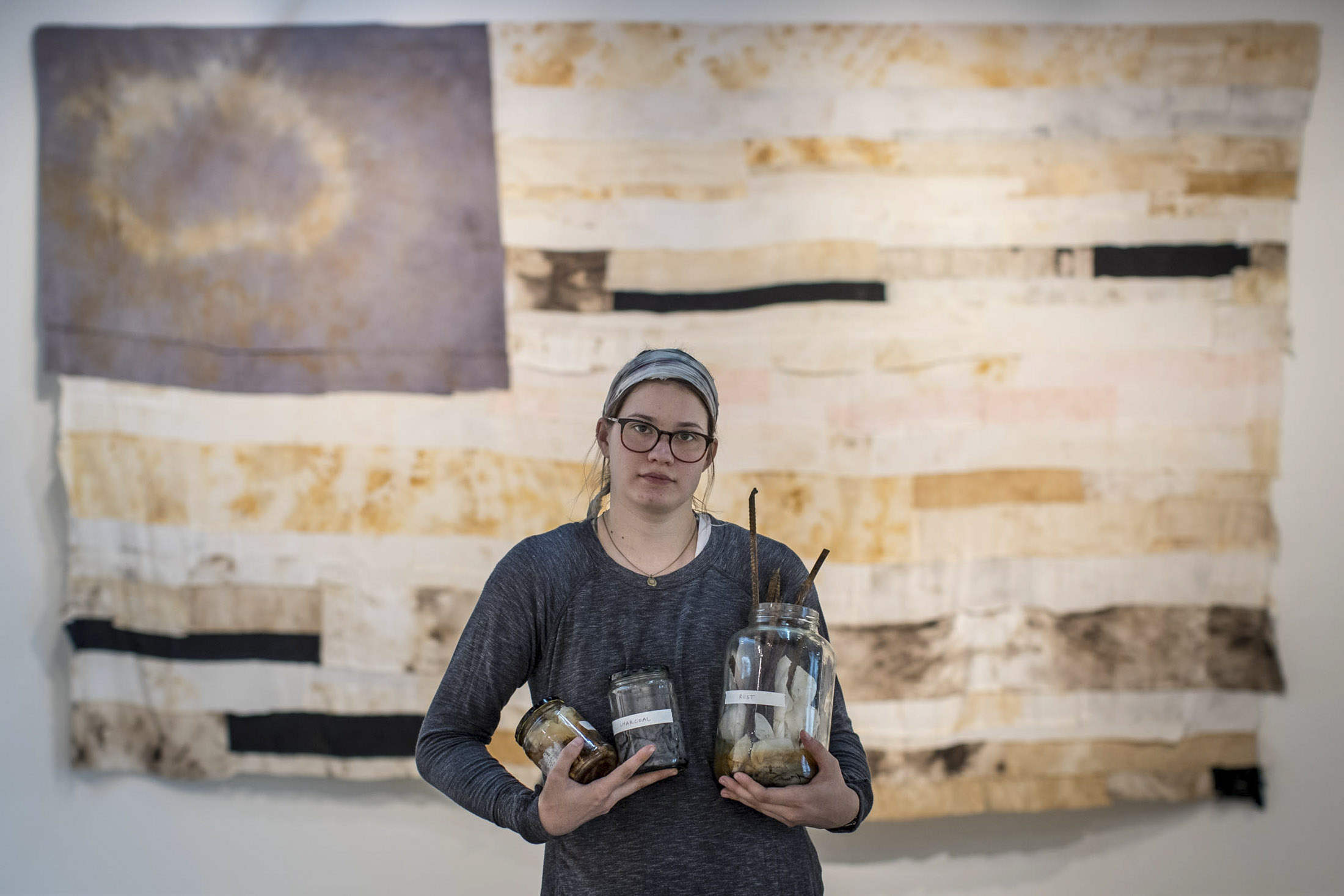 Alex Chiscoe holding glass jars filled with things