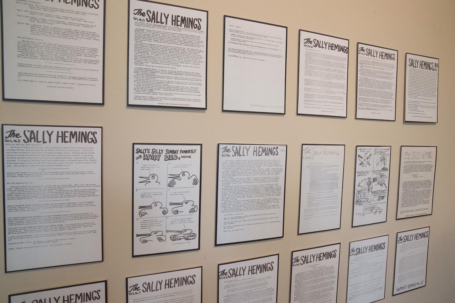 Three rows of black and white flyers mounted on a wall
