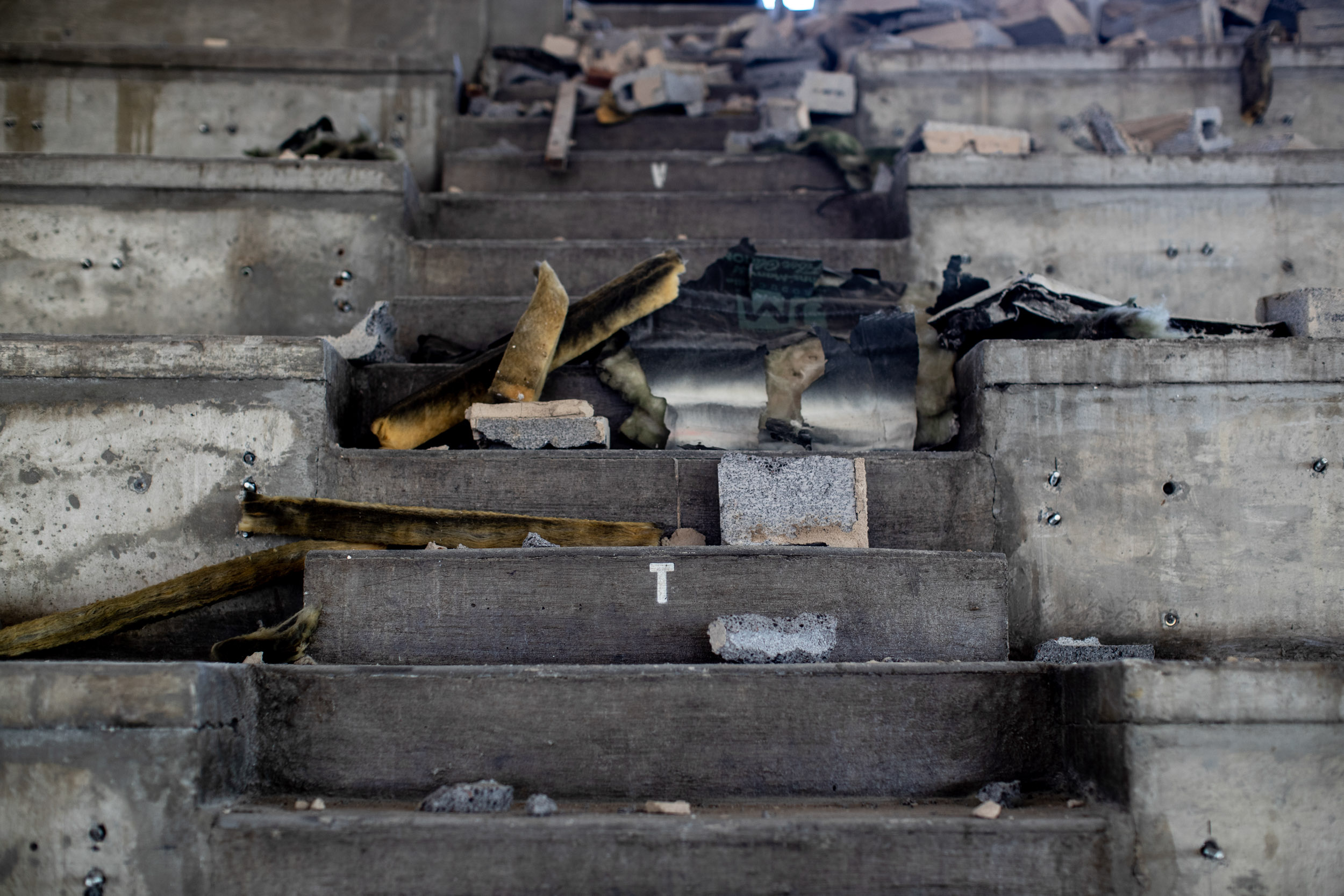 Burnt pieces of wood sit on the concrete steps