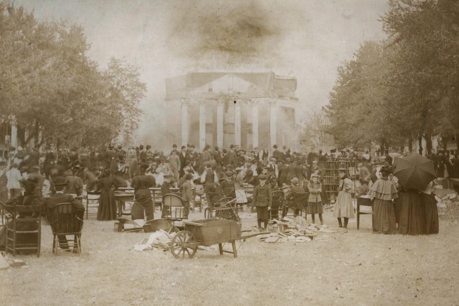 Black and white image of the Rotunda on fire and people gathered on the Lawn