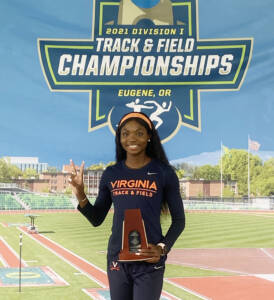 Andrenette Knight giving the peace sign while holding her NCAA trophy