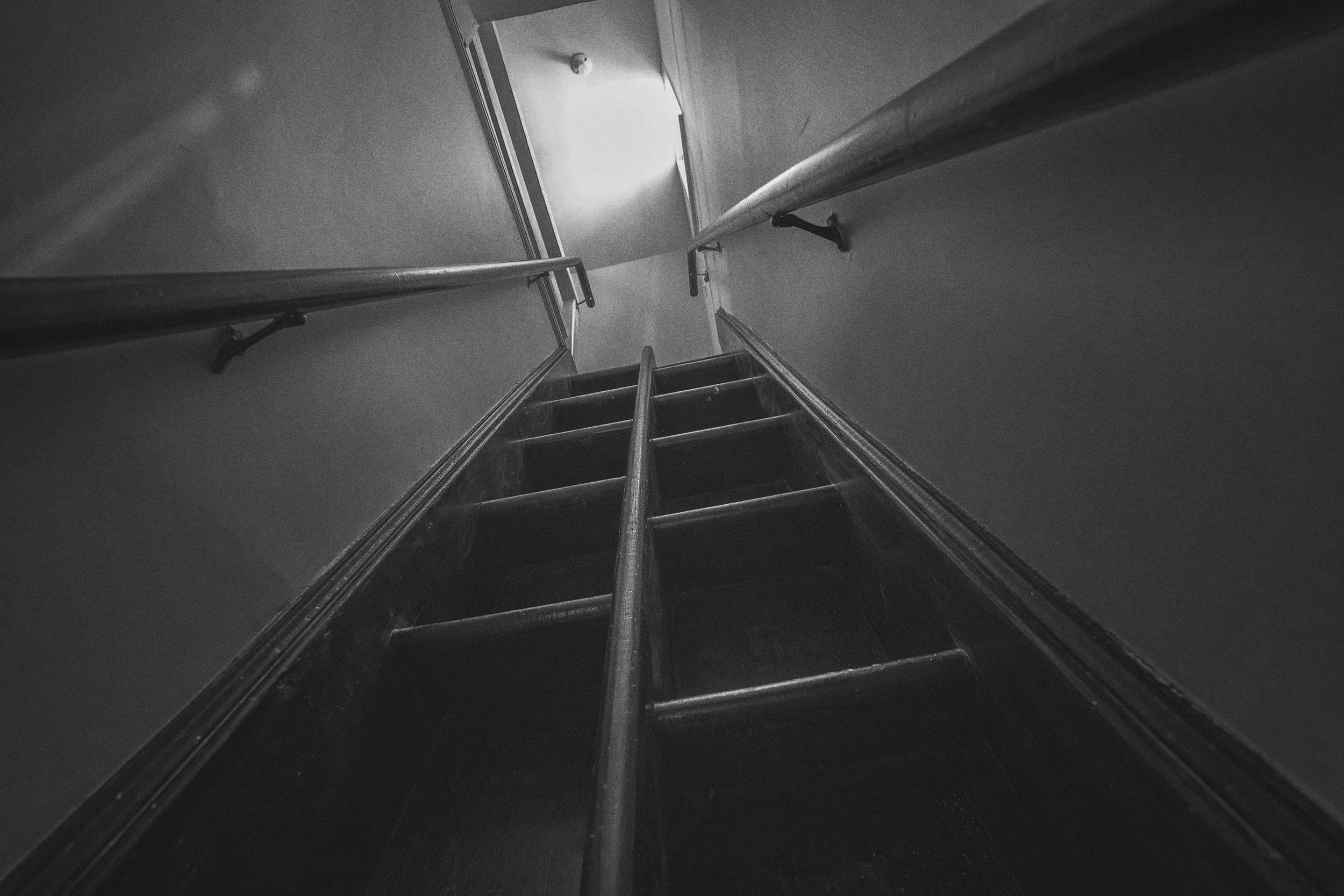 Black and white photo of a steep stairwell in Old Cabell Hall