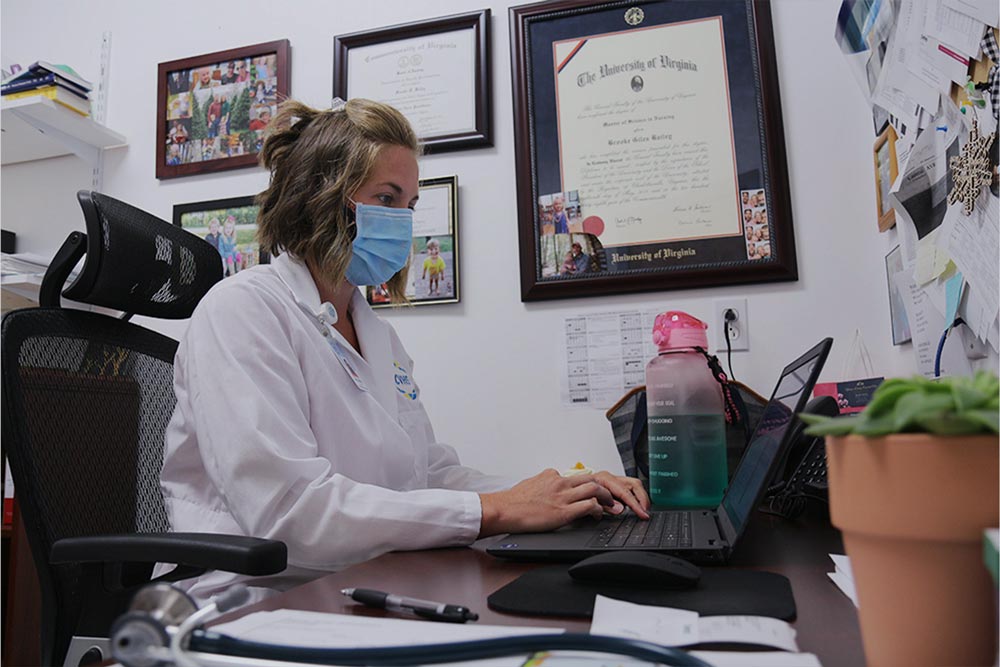 Nurse Practitioner working at a laptop in their office