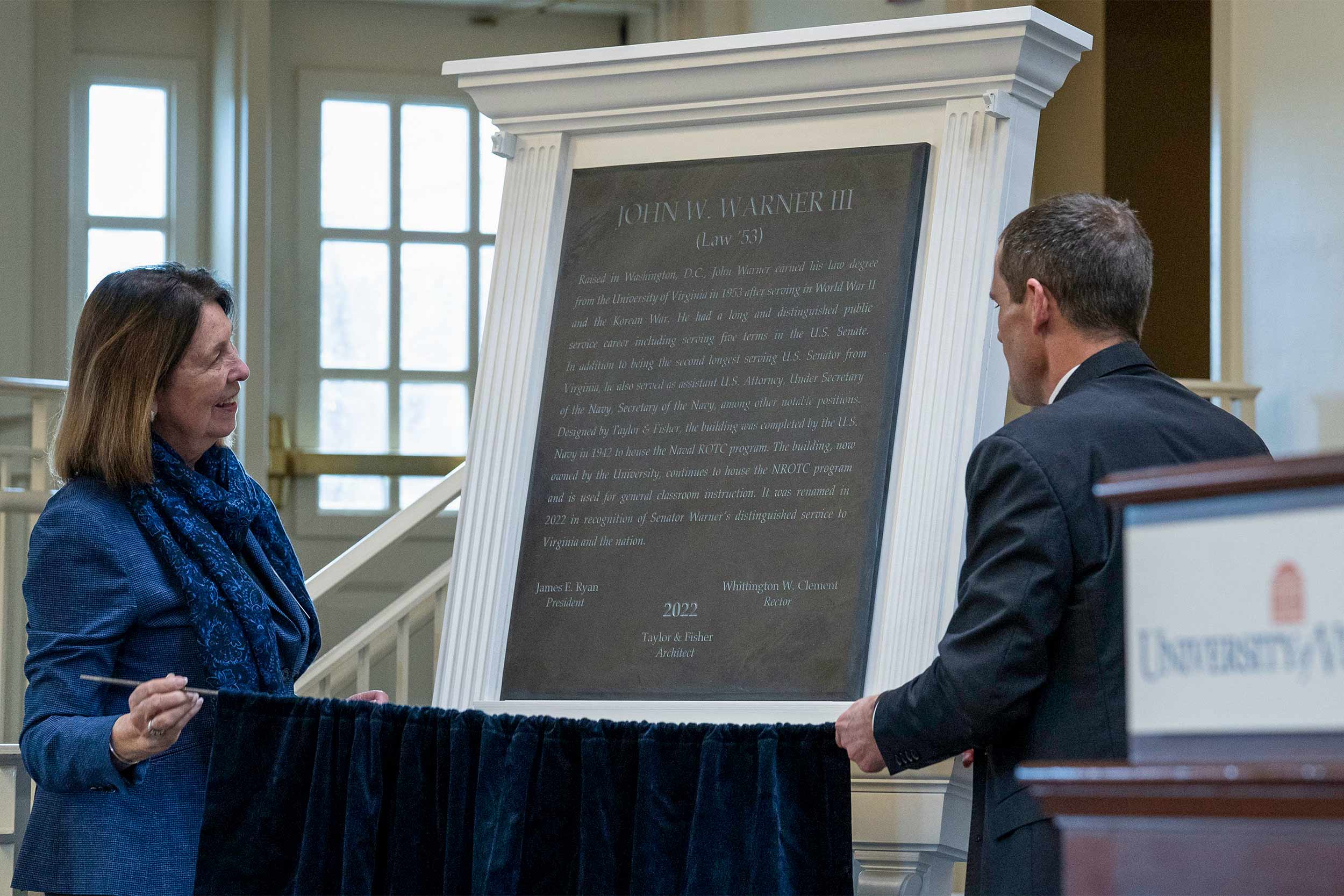Jeanne Warner and Ryan unveil the plaque for the late Sen. John Warner, after whom the Naval ROTC building has been renamed. (Photo by Dan Addison, University Communications)