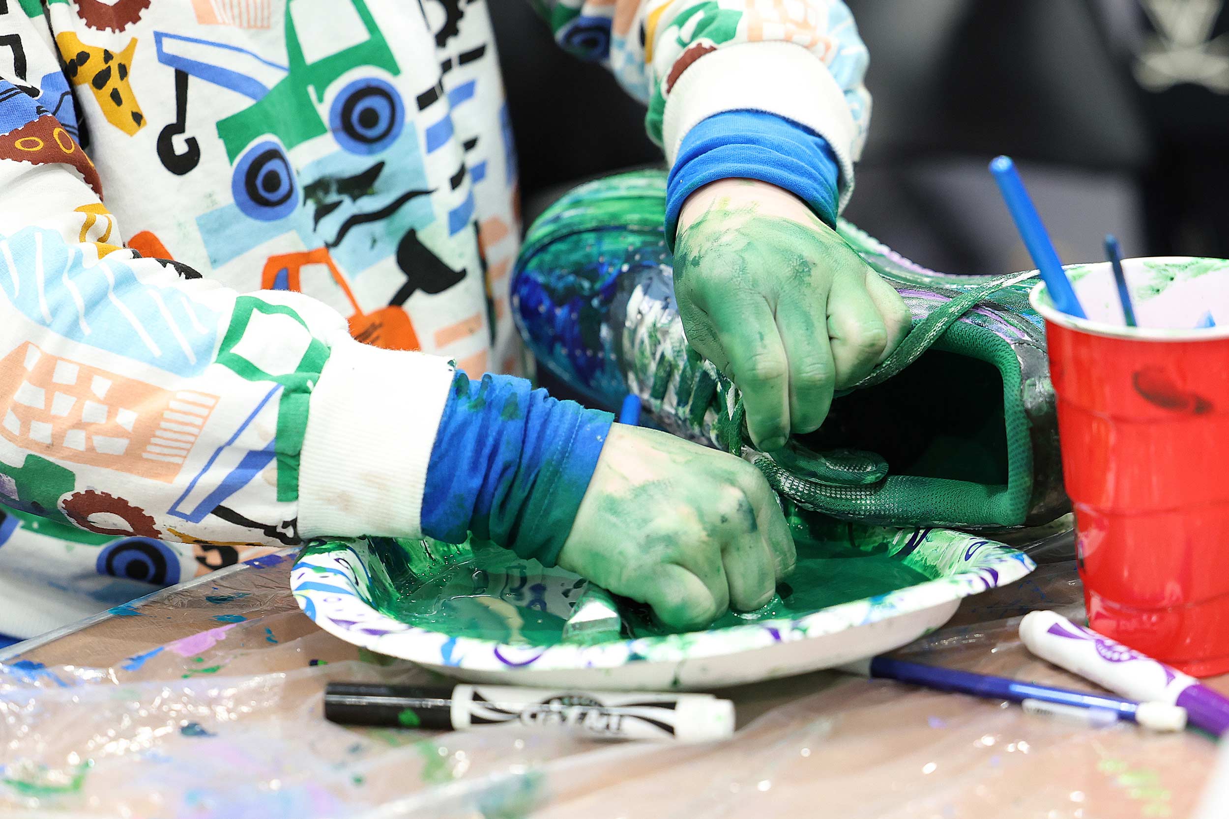 A close up of a shoe being dyed in green paint