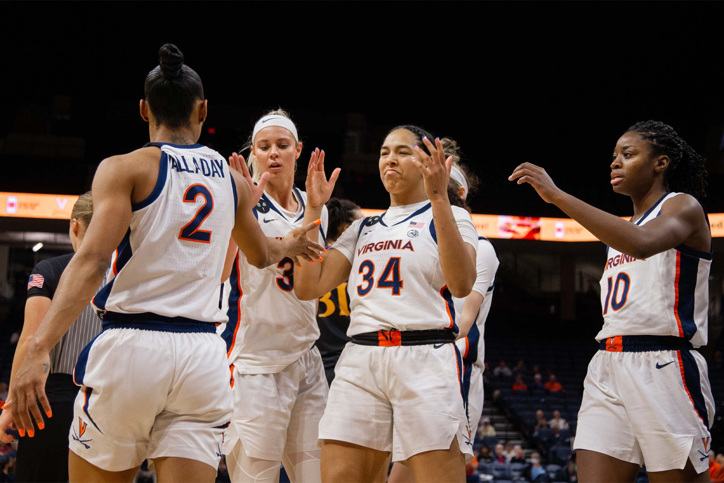 UVA womens basketball team giving high fives on the court