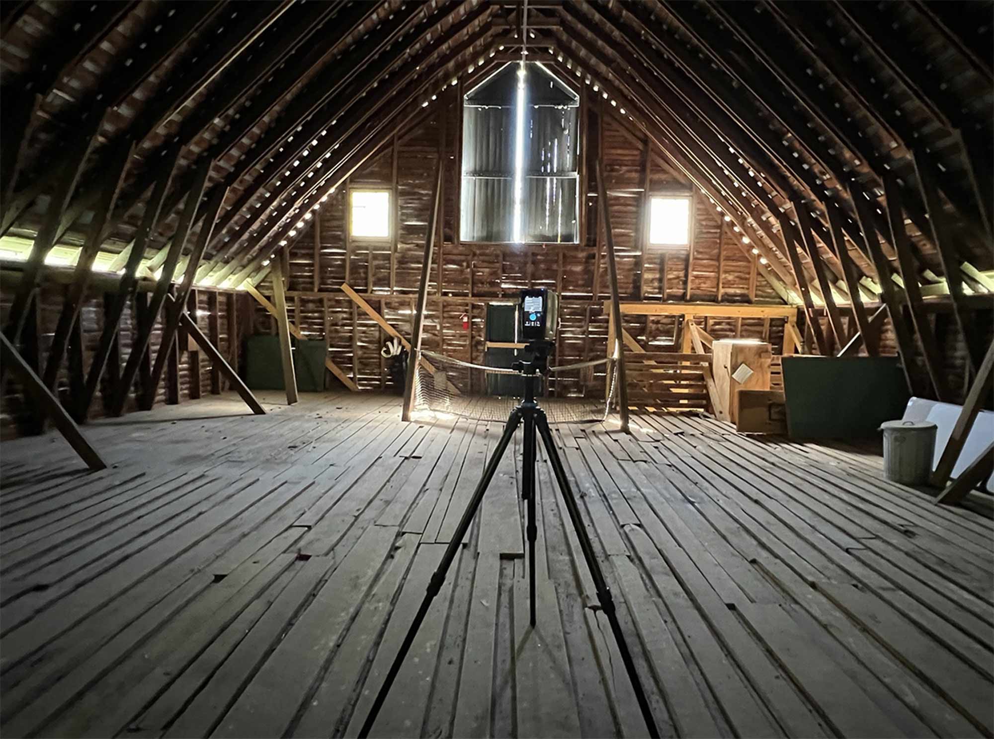 A scanner set up on a tripod in an upper level of the barn