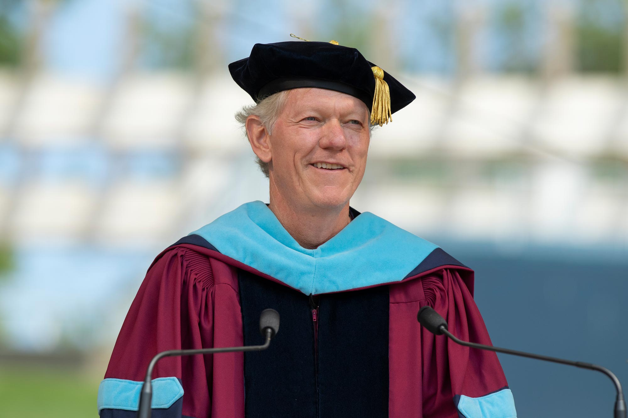 Scott Beardsley in gown and cap speaking at UVA Final Exercises in 2021
