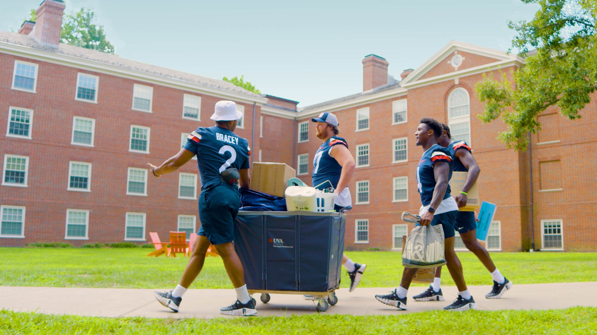 Football players escorting belongings to their new dorm