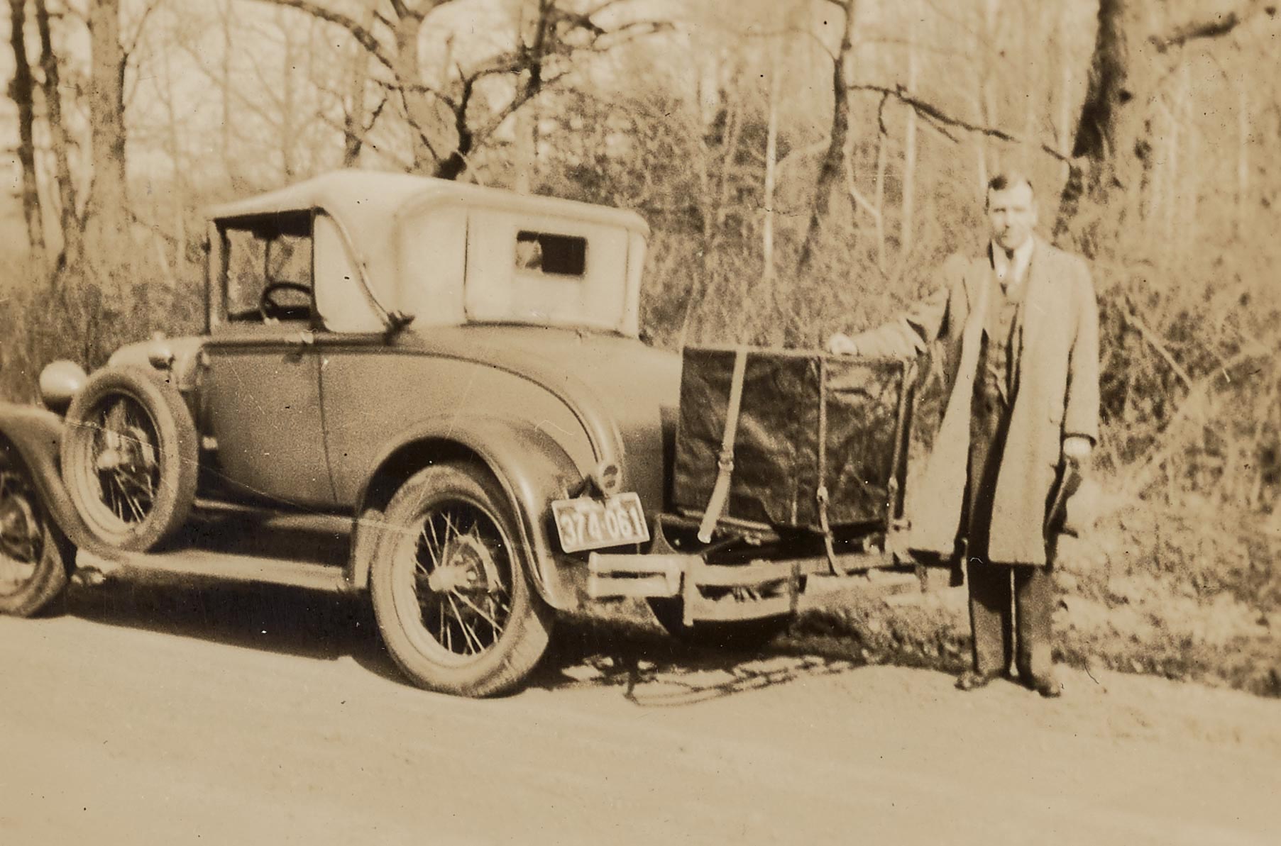 vintage photo of Arthur Kyle Davis Jr. standing next to an old truck