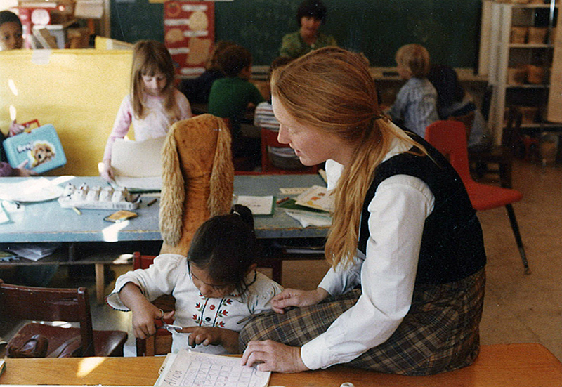 Woman working with small children at a table