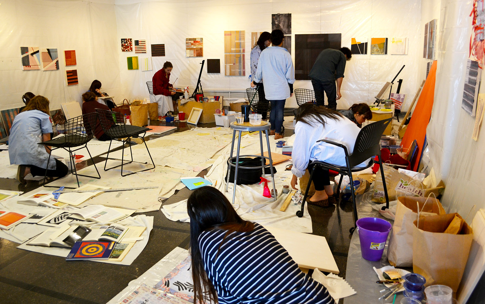 Students sitting on the ground painting