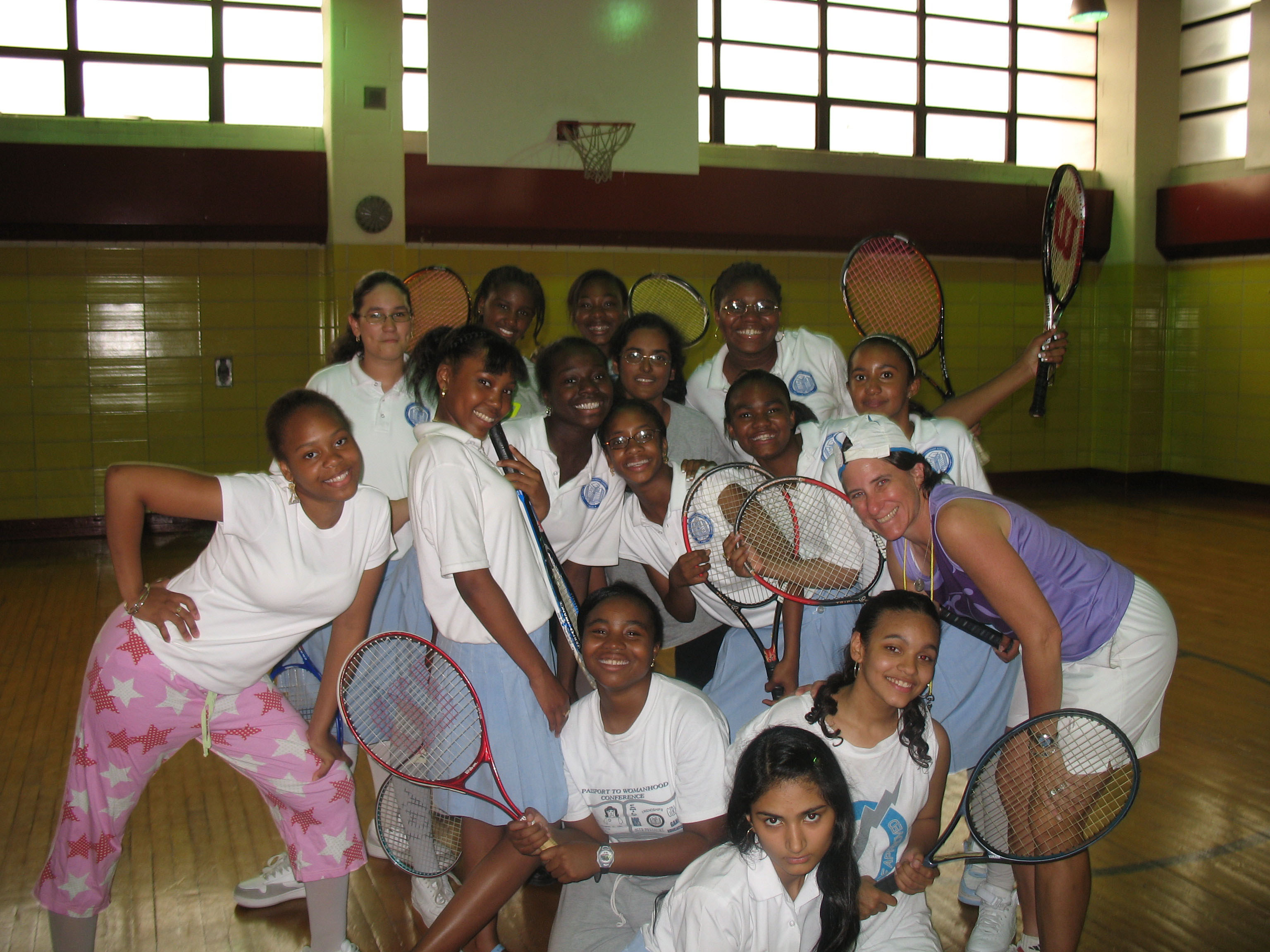 Ellen Markowitz with the 7th-grade girls holding tennis racquets smiling for the camera