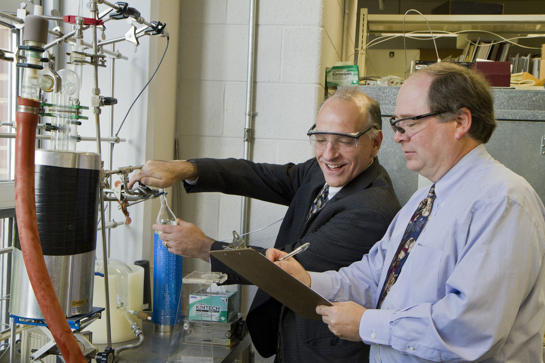 Matthew Neurock and Robert J. Davis work on a machine together in the lab