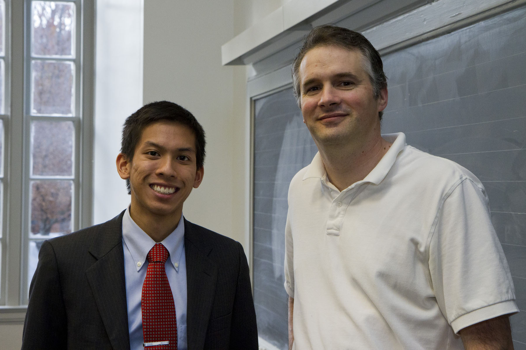 Ken Tran and Dr. Paul Yates stand together smiling at the camera