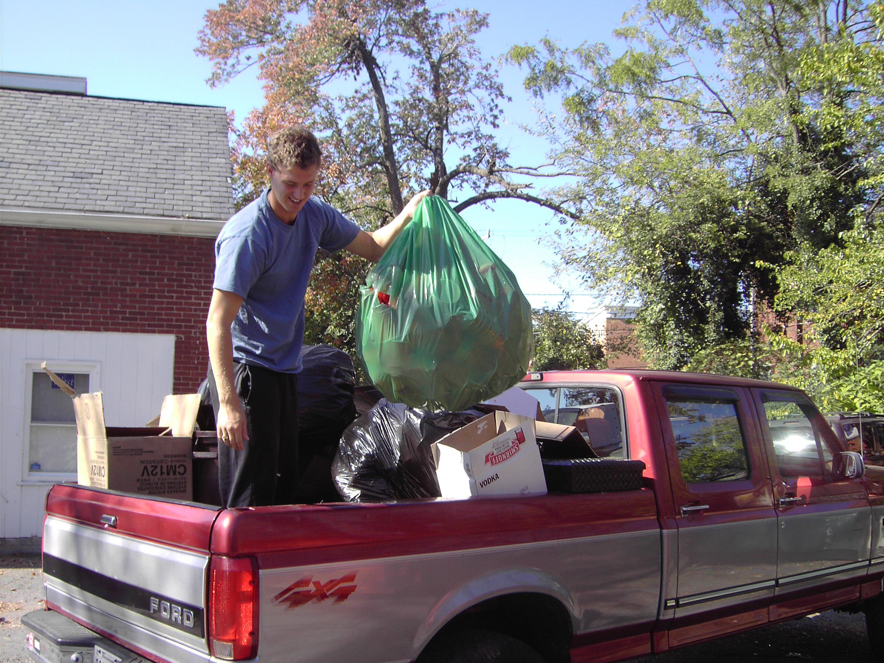 Man standing in the back of a pickup truck placing donated items in the bed