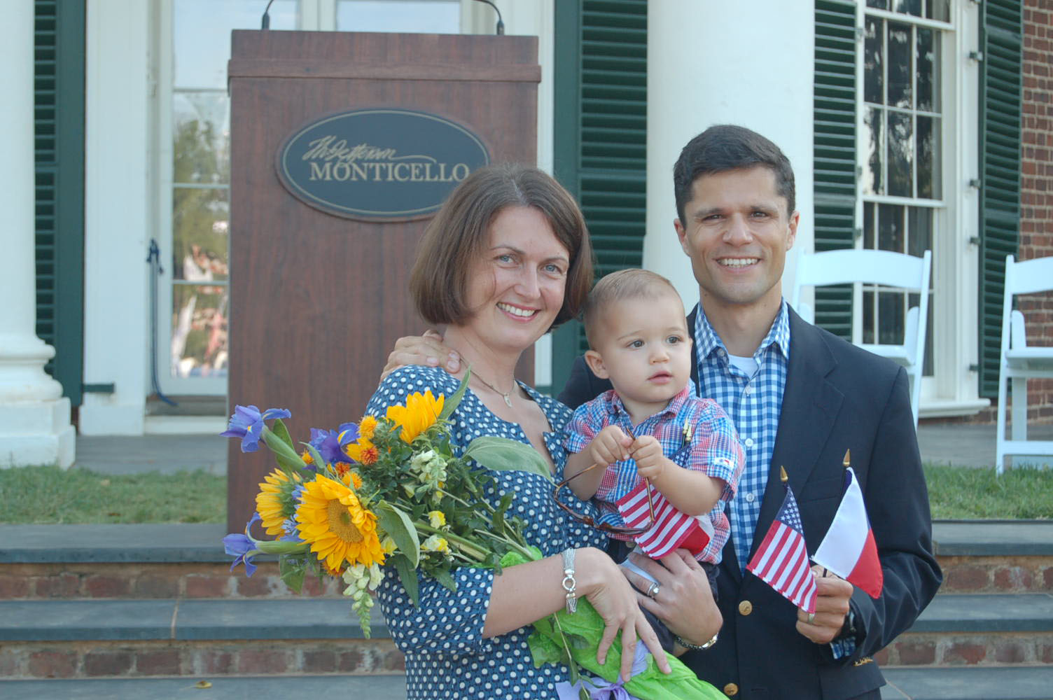 Ladislava "Ladi" Carr,  Sean Carr, her son, and Sebastian Dabney Carr stand together holding American flags during a Naturalization ceremony