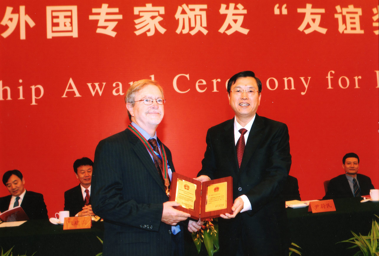 Brantly Womack receiving and award from Zhang Dejiang on stage at an event