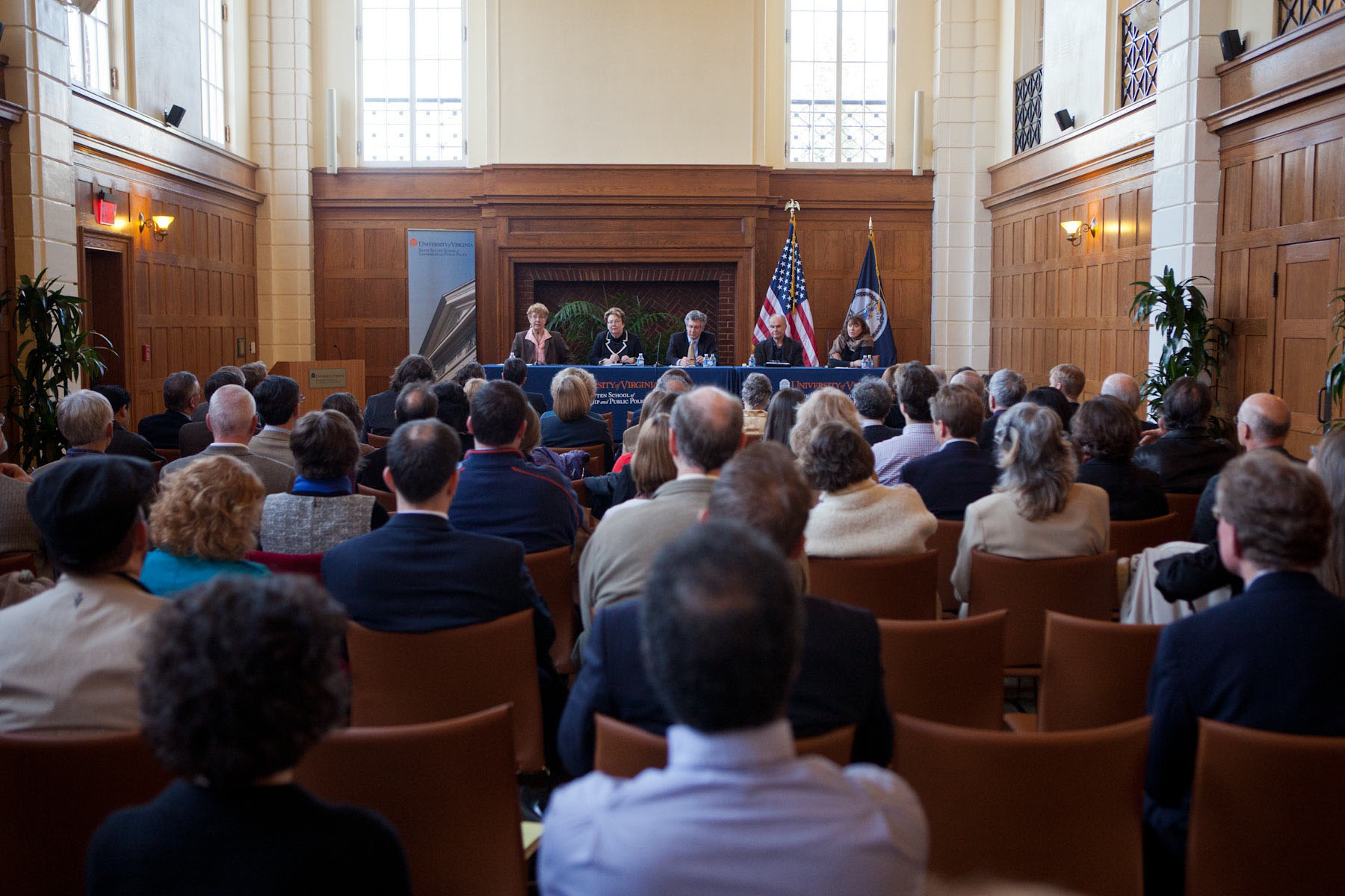 Panel of speakers sit at a table talking to a crowd