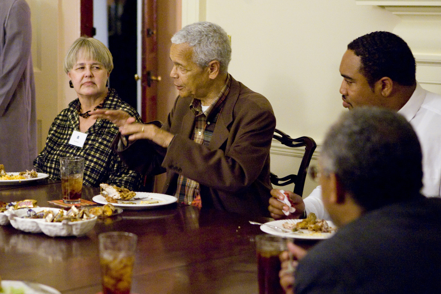 Julian Bond talking to a group of people at a dinner table