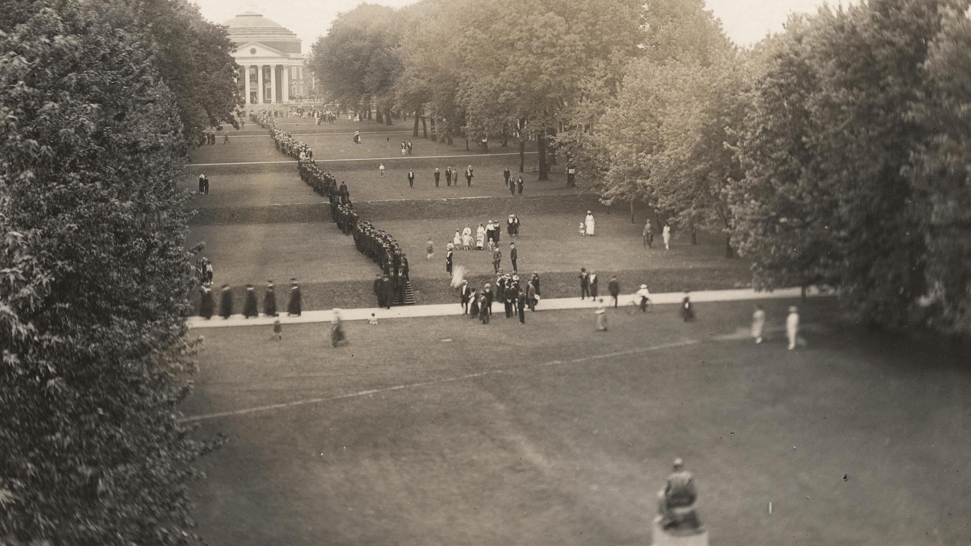 Black and white image of graduates walking the lawn in 1921 from the Rotunda