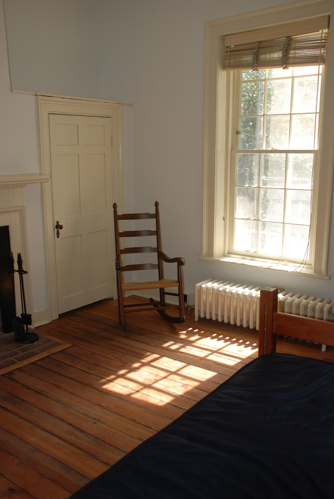 Wooden rocking chair in a lawn room next to a window
