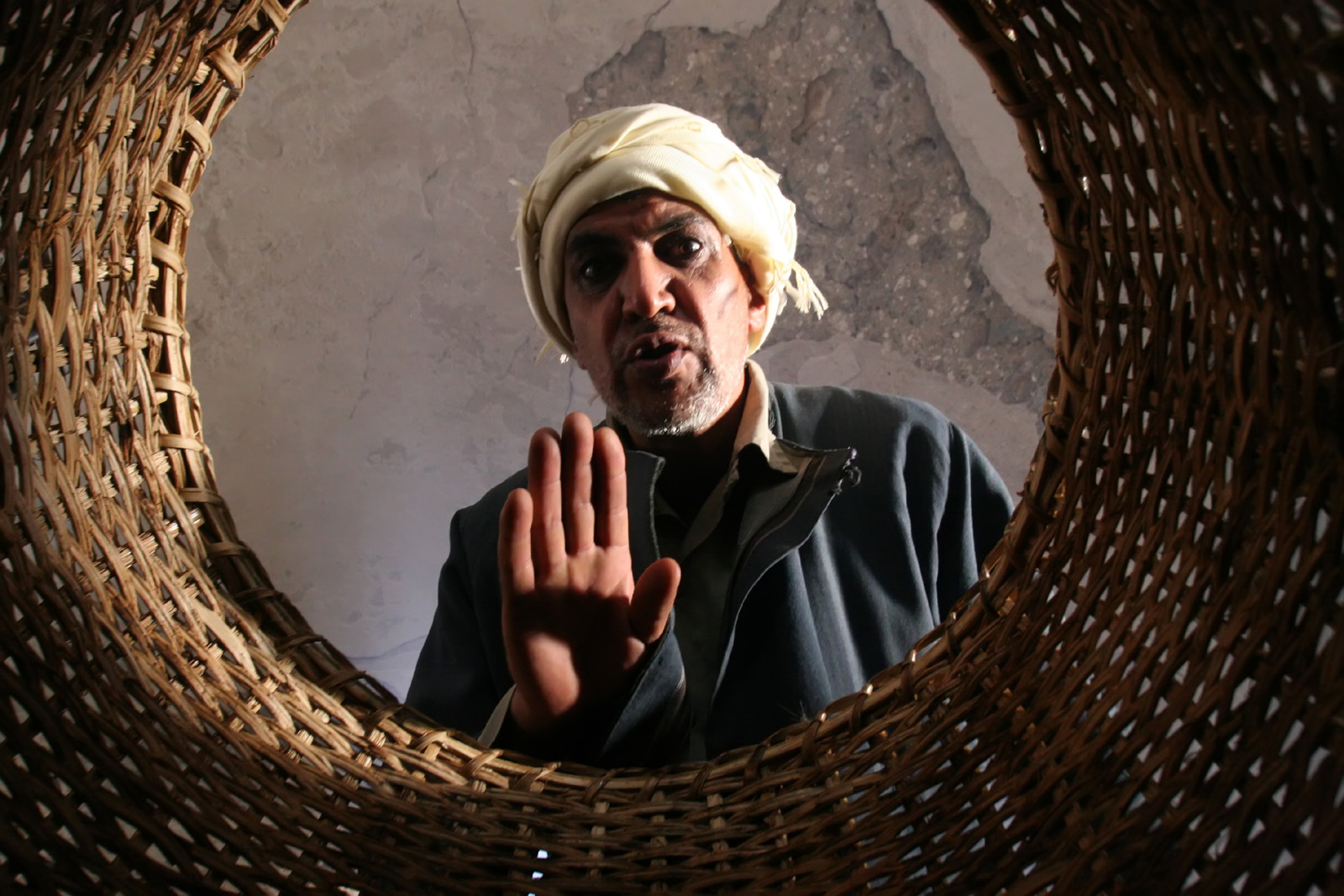 Man wearing a Turban looks down at the camera that is in a woven basket