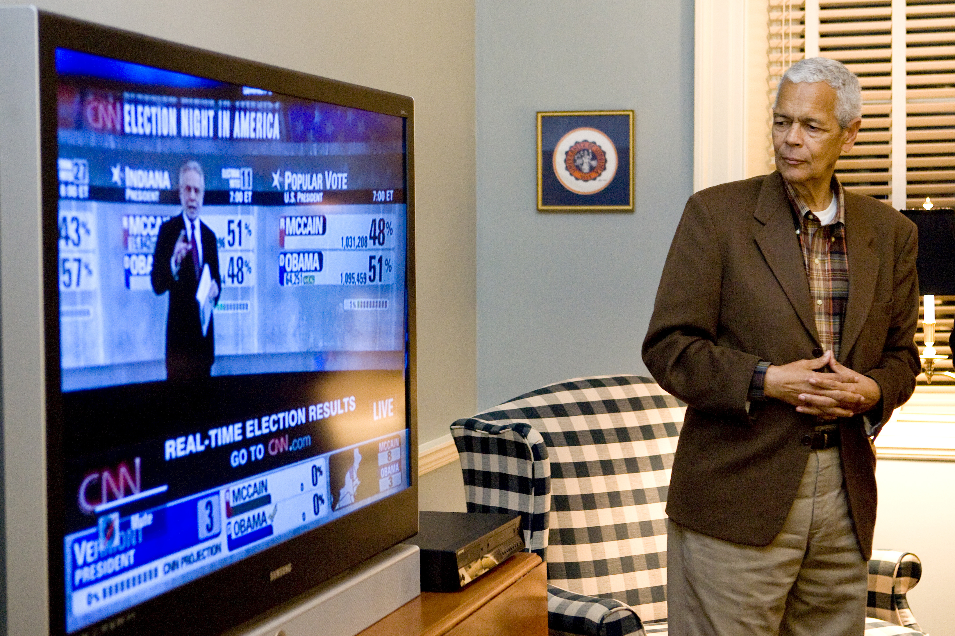 Julian Bond standing watching a CNN news broadcast of a presidential election