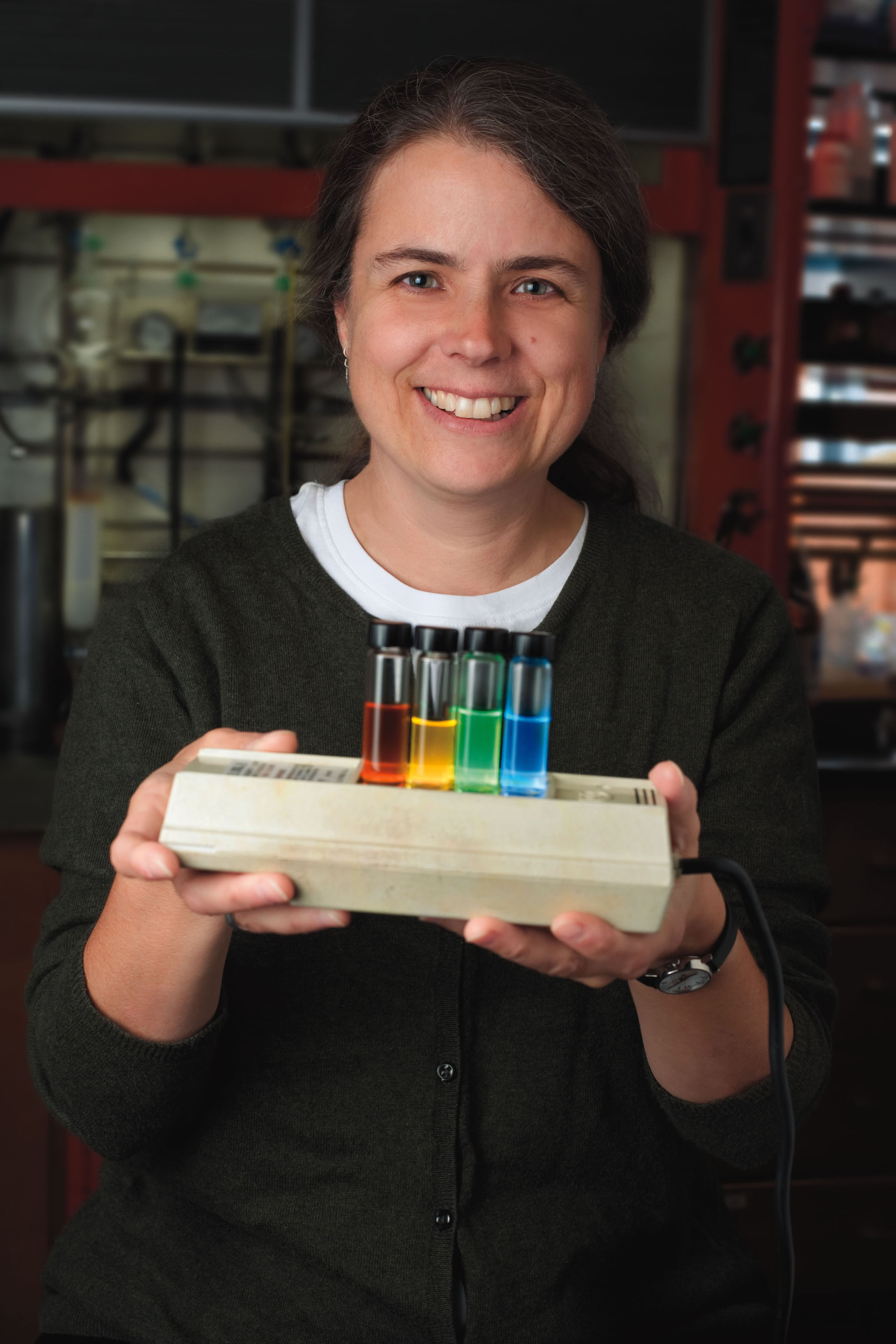 Cassandra Fraser holds four test tubes of different colors 