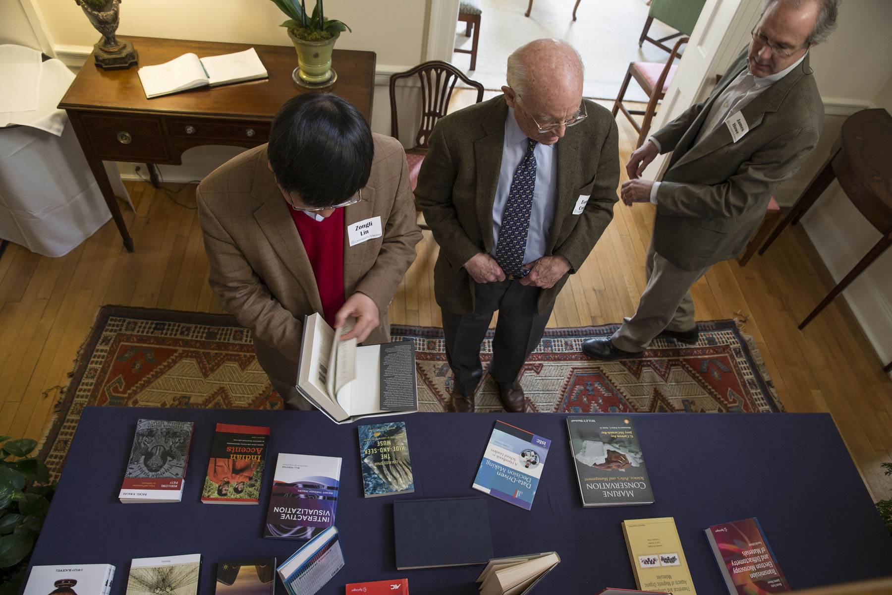 Professors looking at books on a table