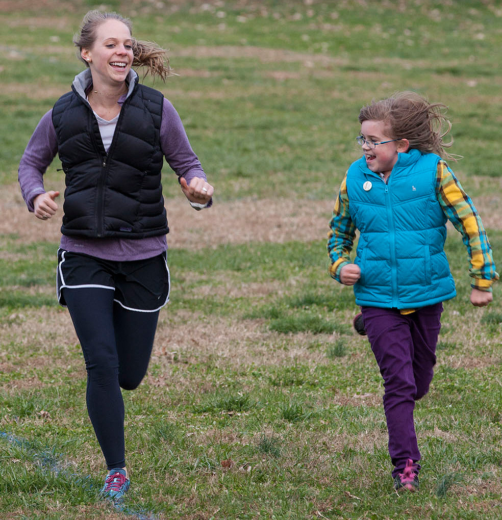 UVA student running along with a child
