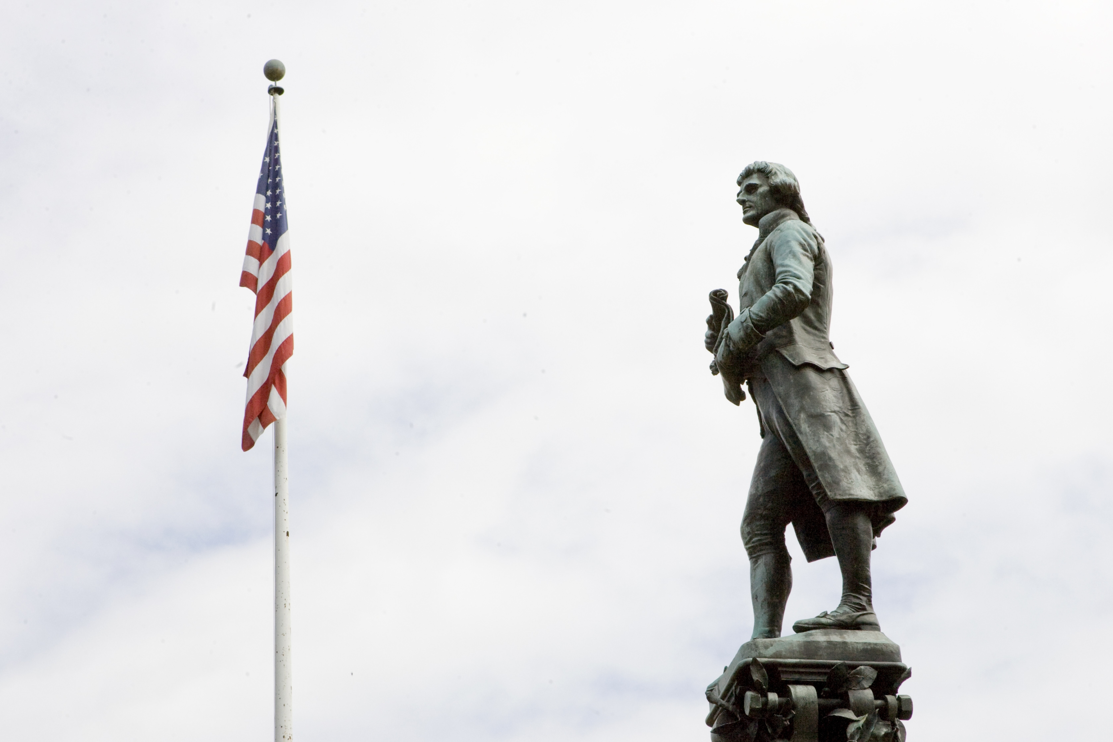 Thomas Jefferson statue next to the United States Flag