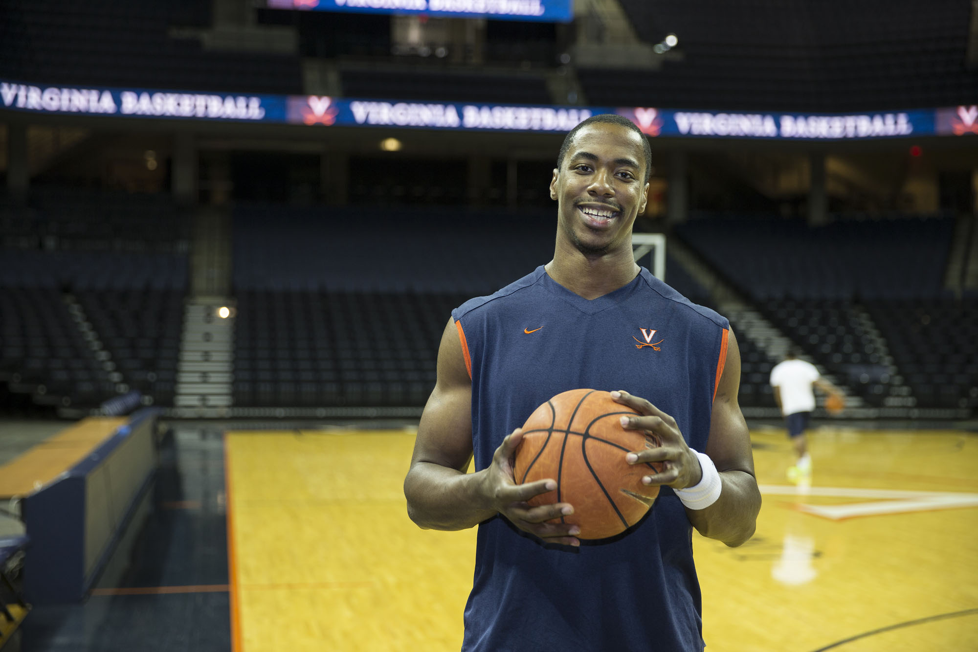 Jerome Meyinsse holding a basketball smiling at the camera