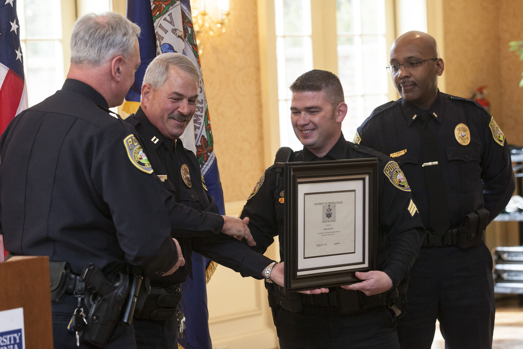 Sgt. Casey Accord (center) shakes fellow officers hands while receiving an award