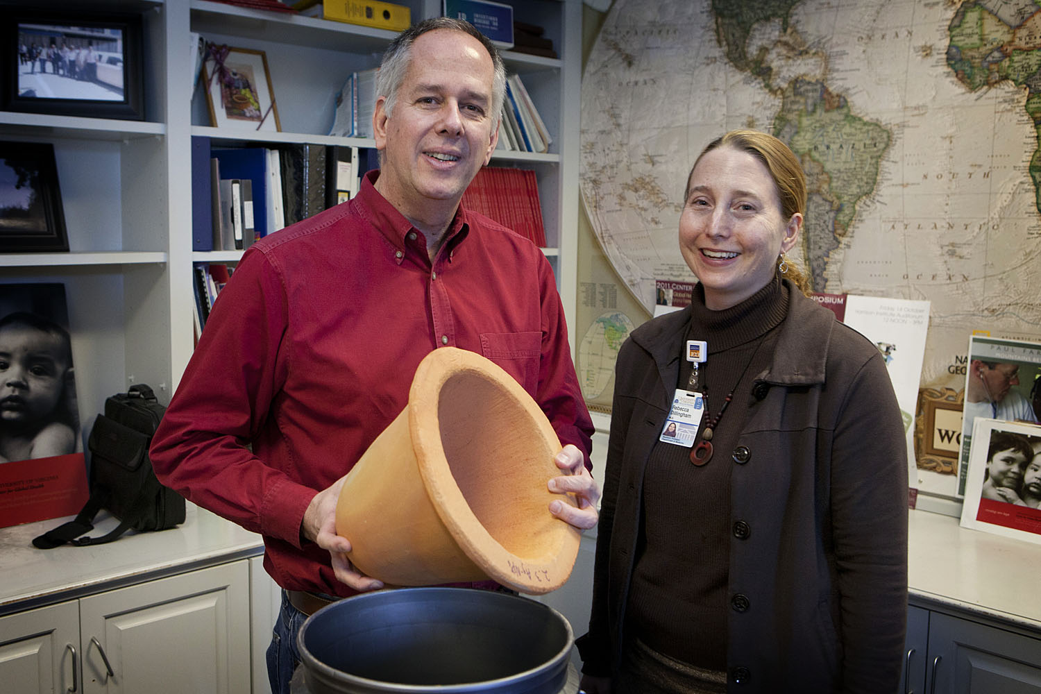 Jim Smith and Dr. Rebecca Dillingham stand together smiling at the camera holding a ceramic water filter 