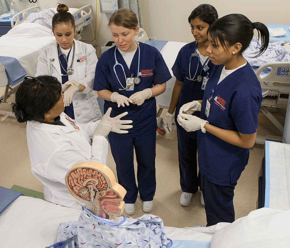 Nursing students listening to a nurse in a simulator lab