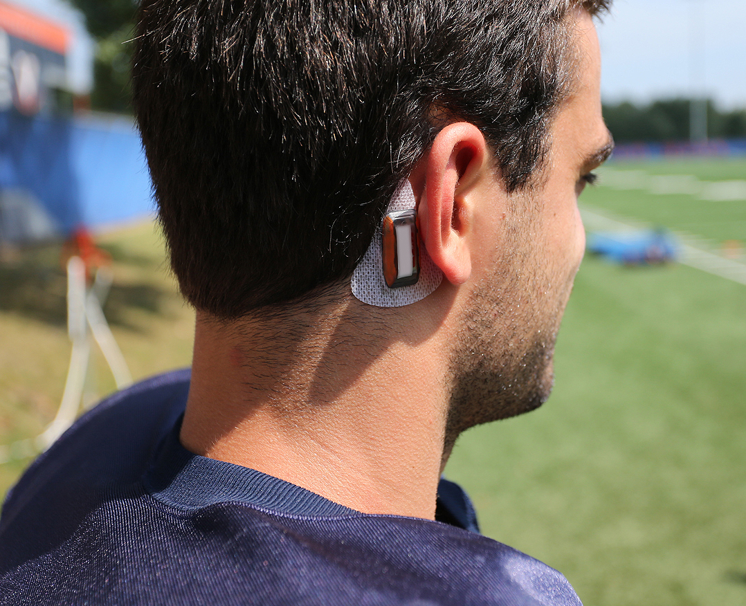 Football player wearing a sensor behind their ear
