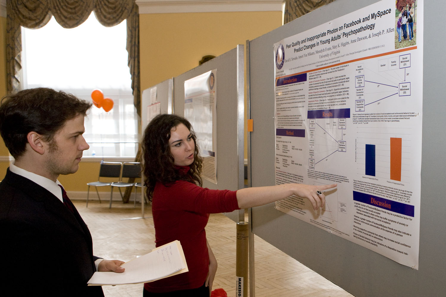 Student presenting her poster to a man