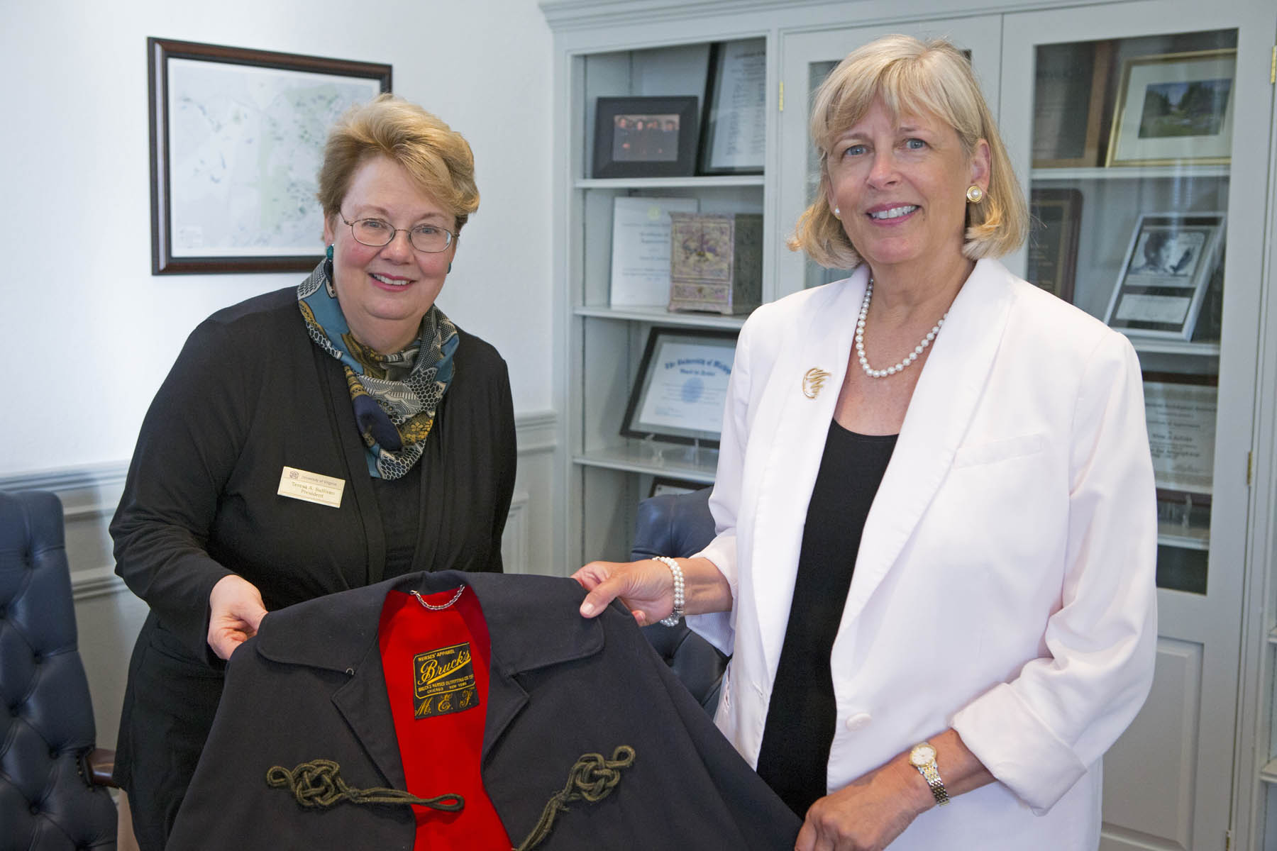 Teresa A. Sullivan, left, holding an old jacket with Dorrie Fontaine, right