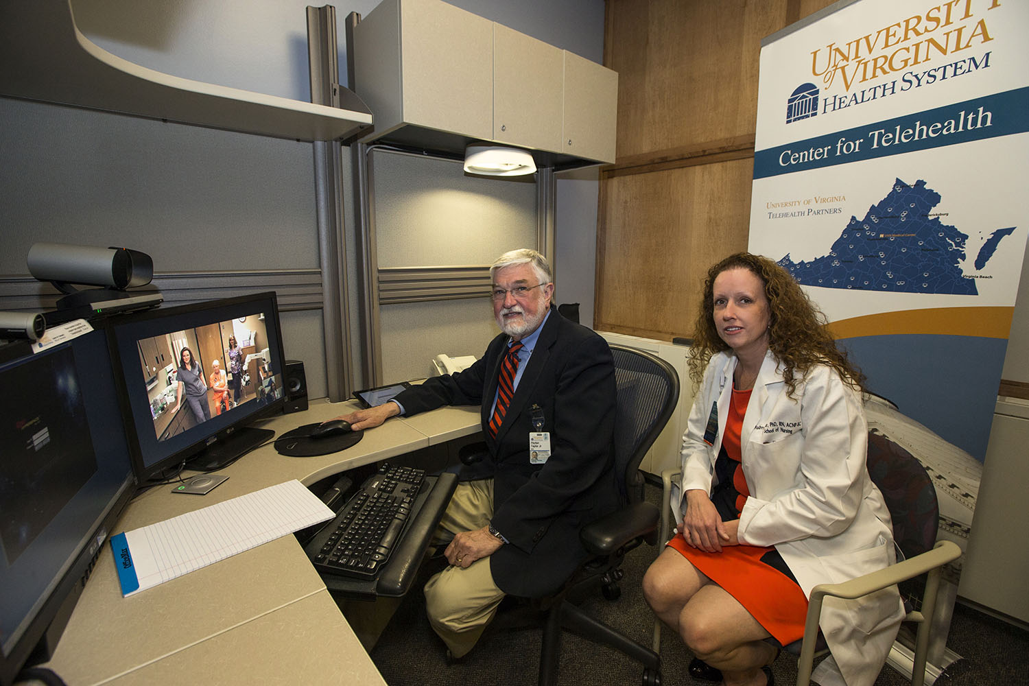 Dr. Peyton Taylor, left, and Audrey Snyder, right, smile at the camera from a desk