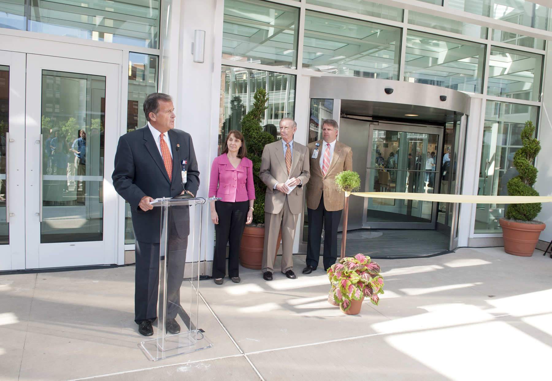 Left to Right: R. Edward Howell, Nancy Dunlap, Pat Hogan and Bo Cofield stand in front of a crowd at ribbon cutting ceremony at the UVA Hospital