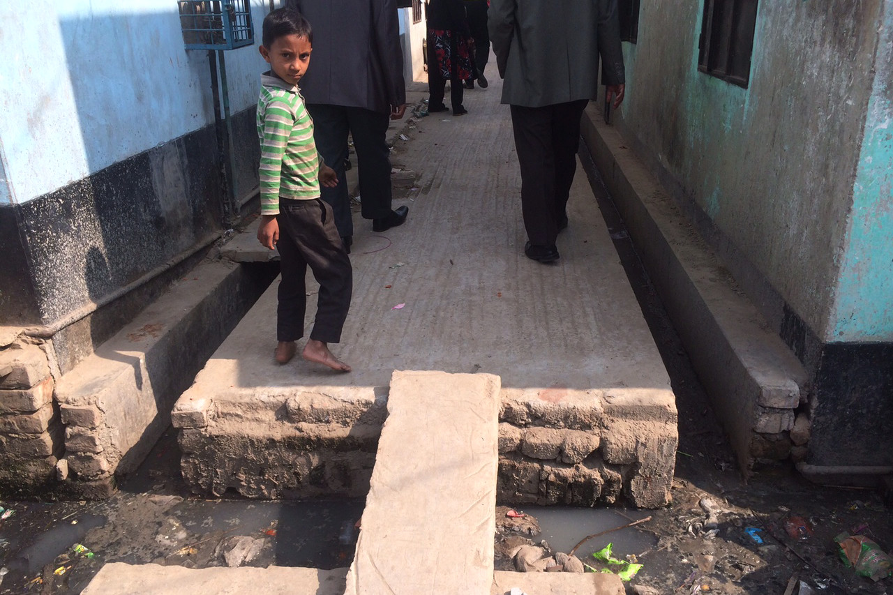 A small child walking in a Bangladeshi slum
