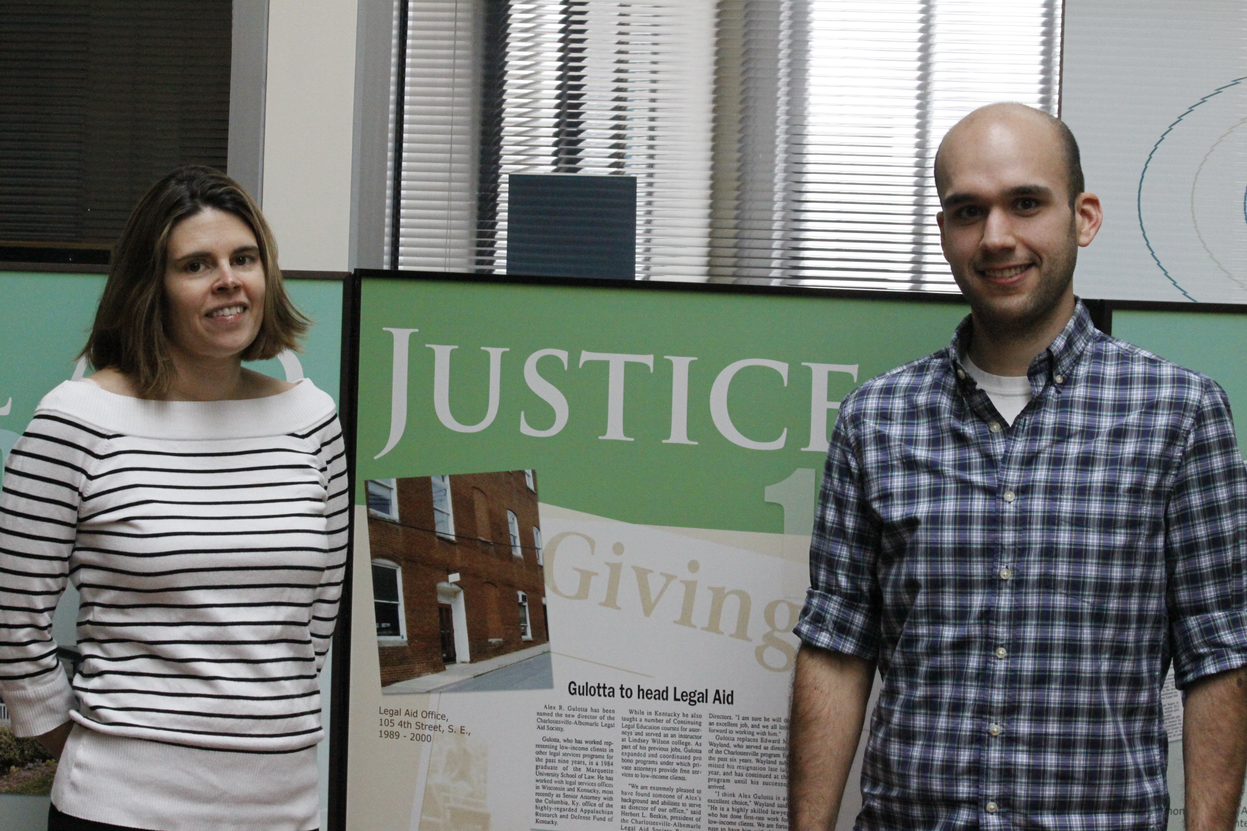 Carolyn Kalantari and Mario Salas stand in front of a poster they made