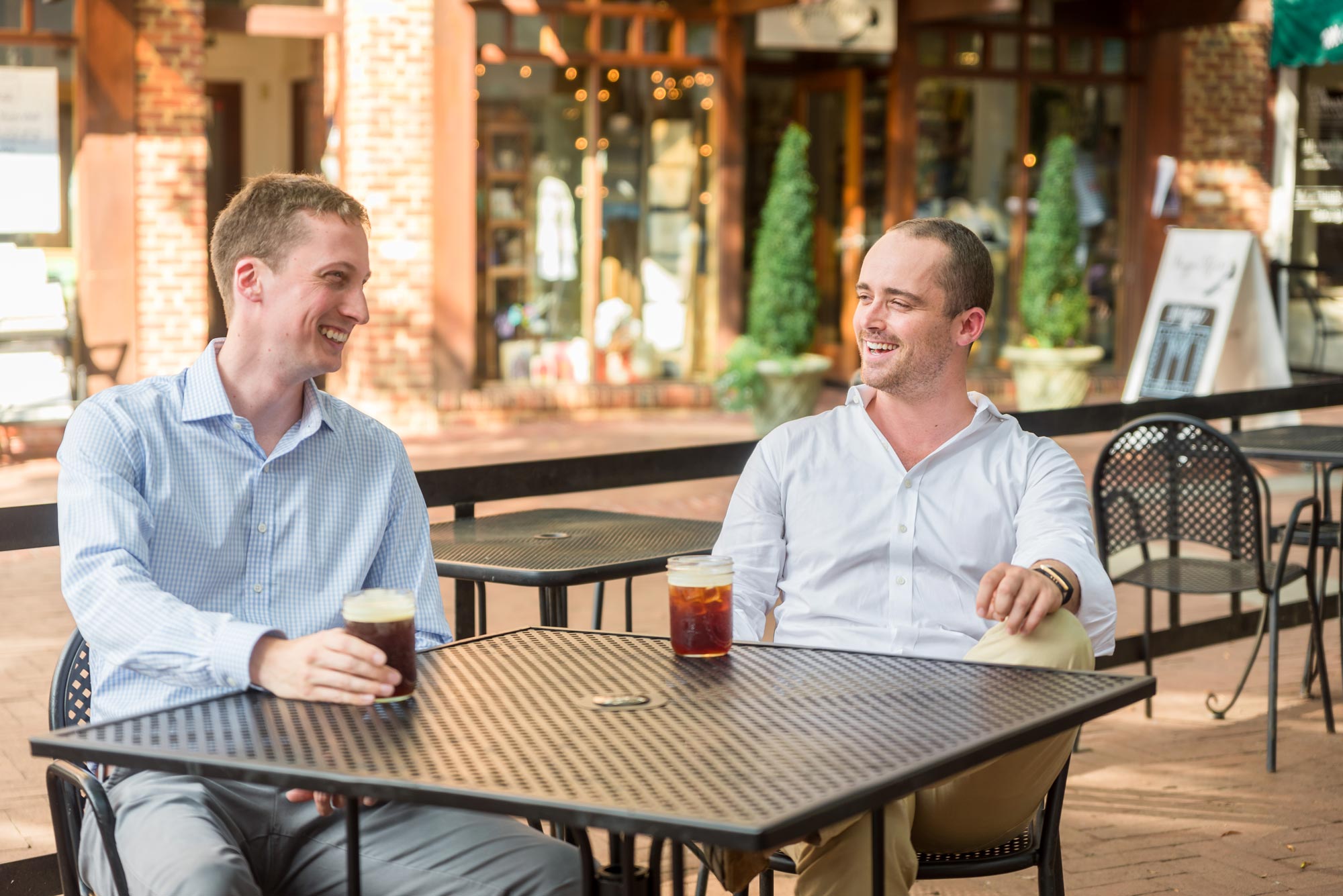 Whit Hunter, right, and Ben Yobp, left, enjoy drinks together at a table on the downtown mall in Charlottesville