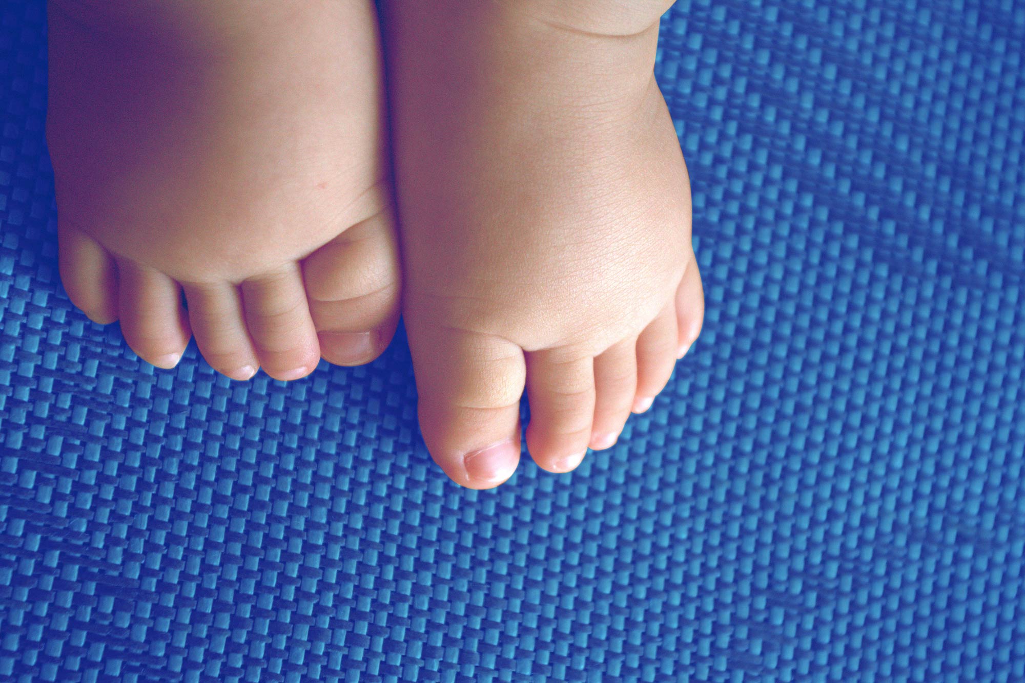 Baby feet on a blue mat