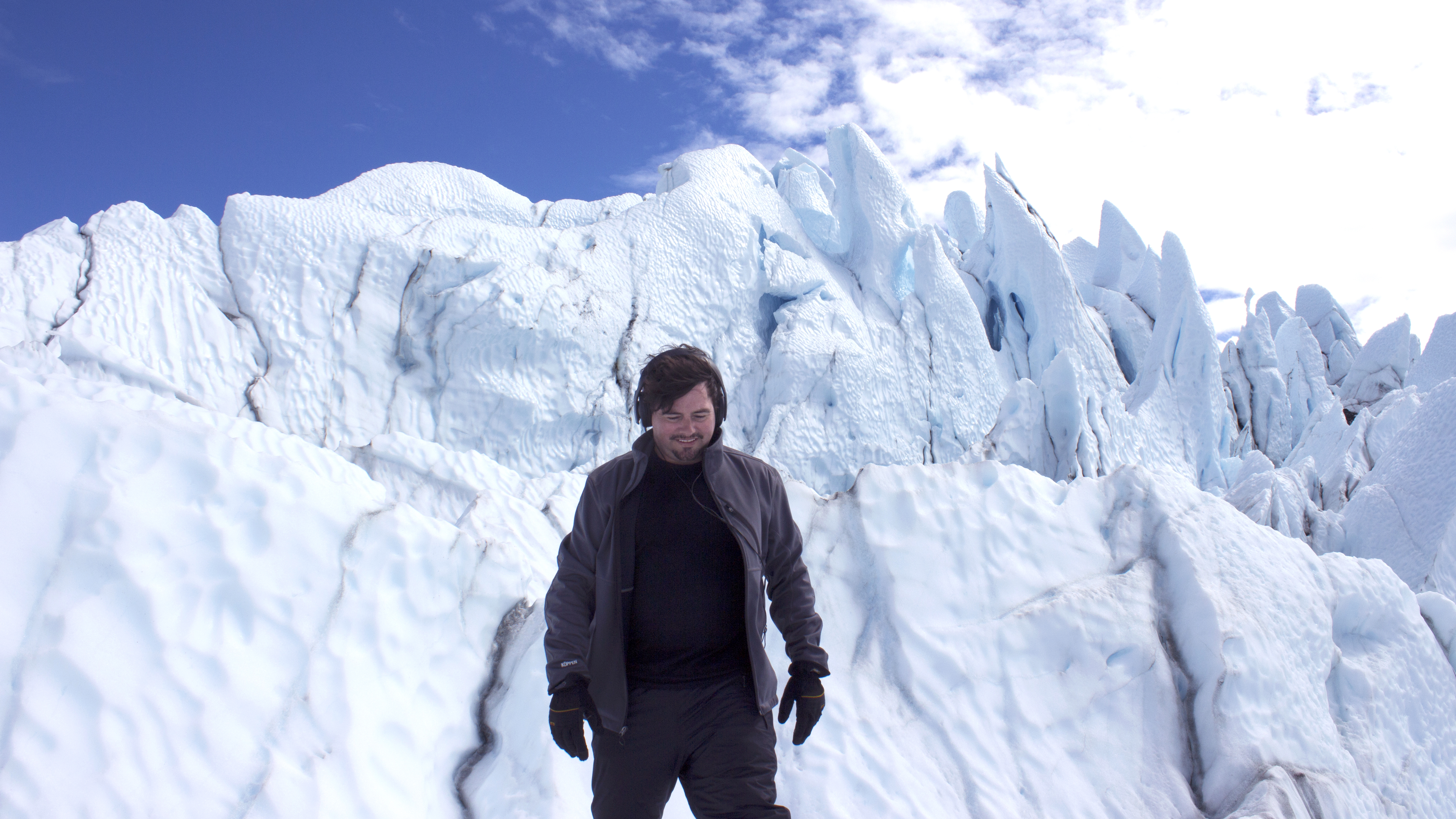 Matthew Burtner, stands in front of a glacier