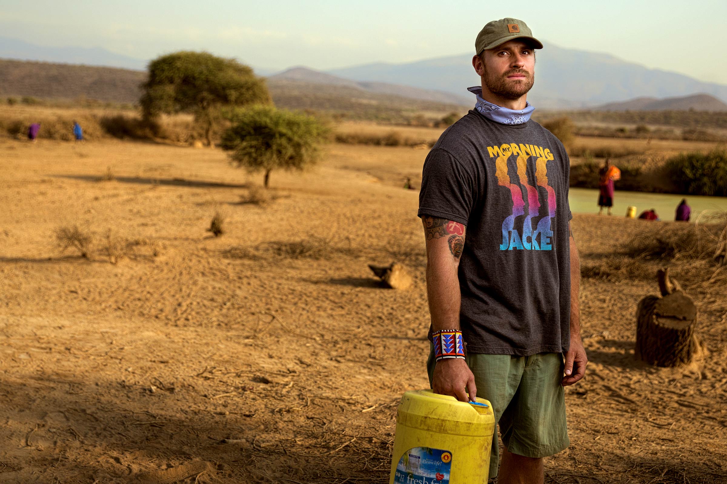 Chris Long holding a yellow bucket of water looking at the camera