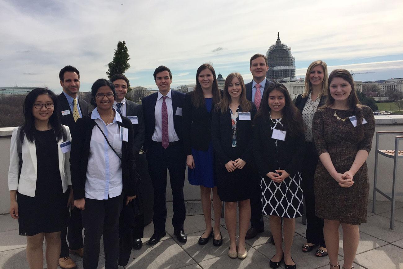 Group photo of UVA students and UVA alumni on top of a building in Washington DC 
